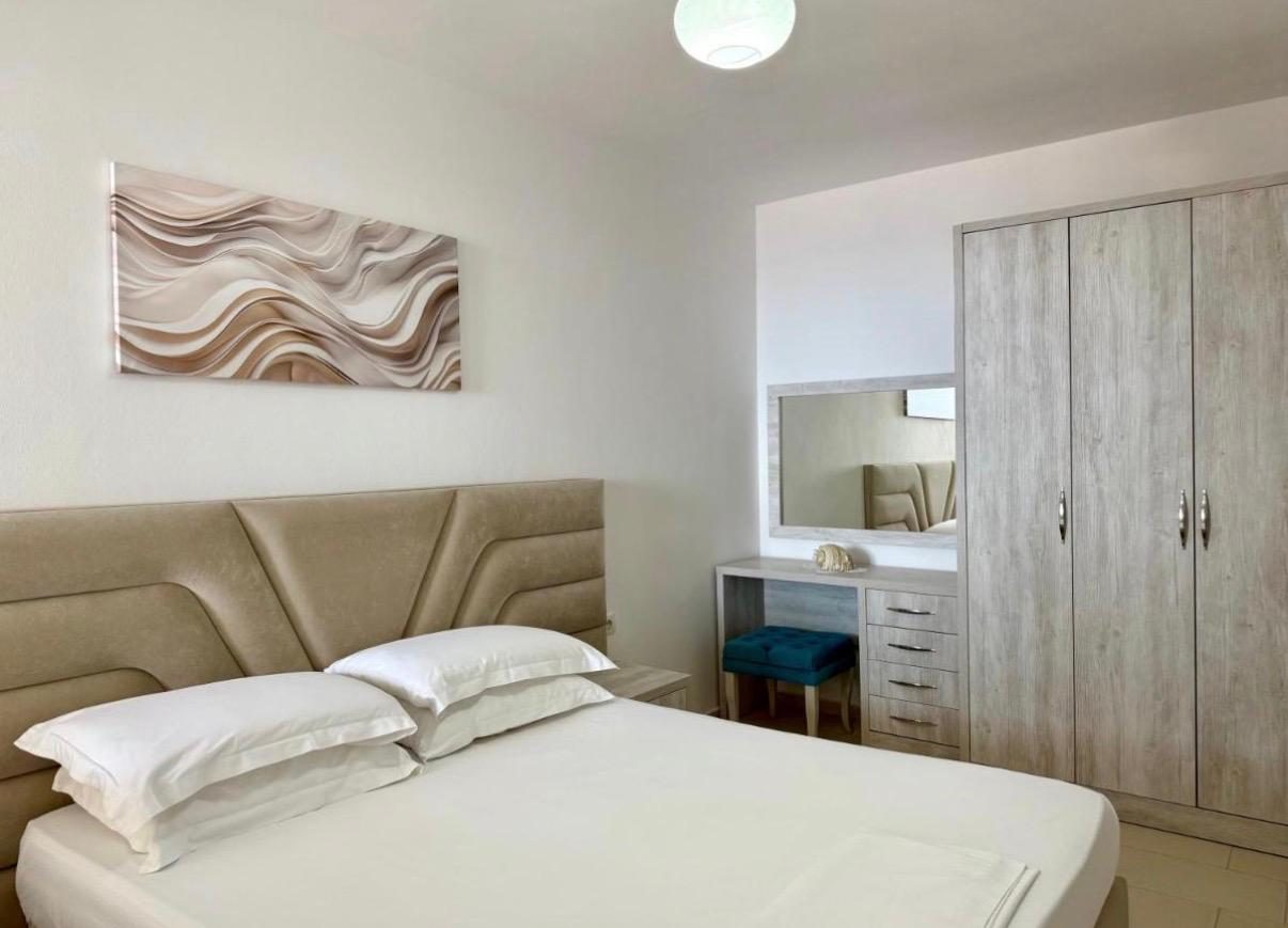 Beige double bedroom with vanity and wardrobes