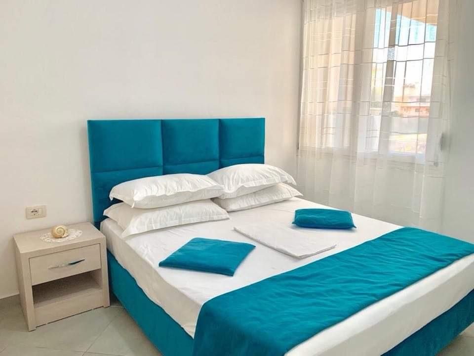 Double bedroom with turquoise bed and fresh linen
