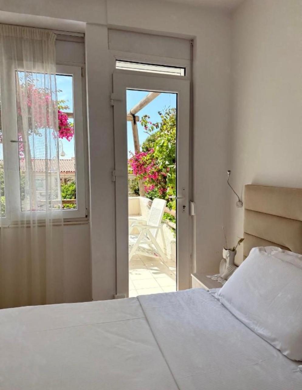 Bedroom opening to a terrace framed by bougainvillea