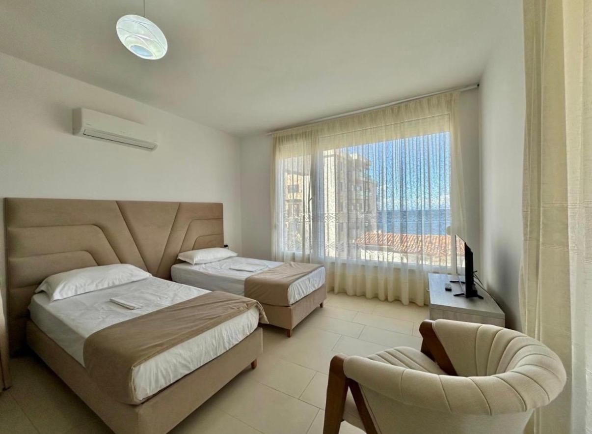 Twin bedroom in beige tones with a sea view window