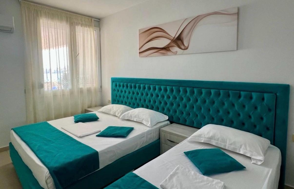 Twin bedroom with teal headboard and harbor view
