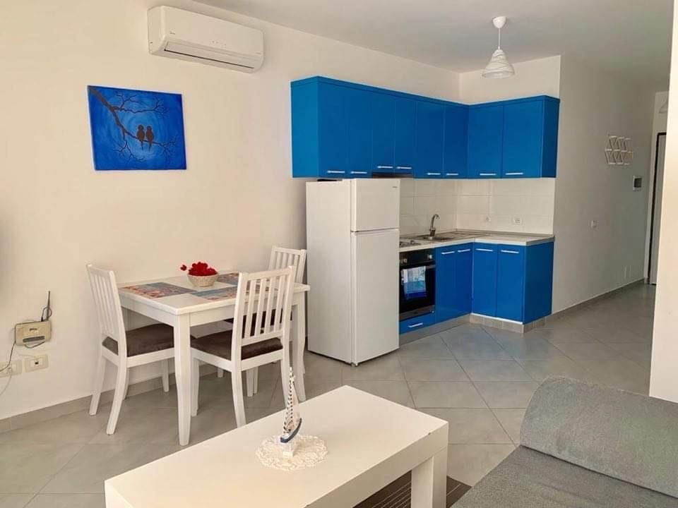 Open-plan kitchen with blue cabinets and dining table
