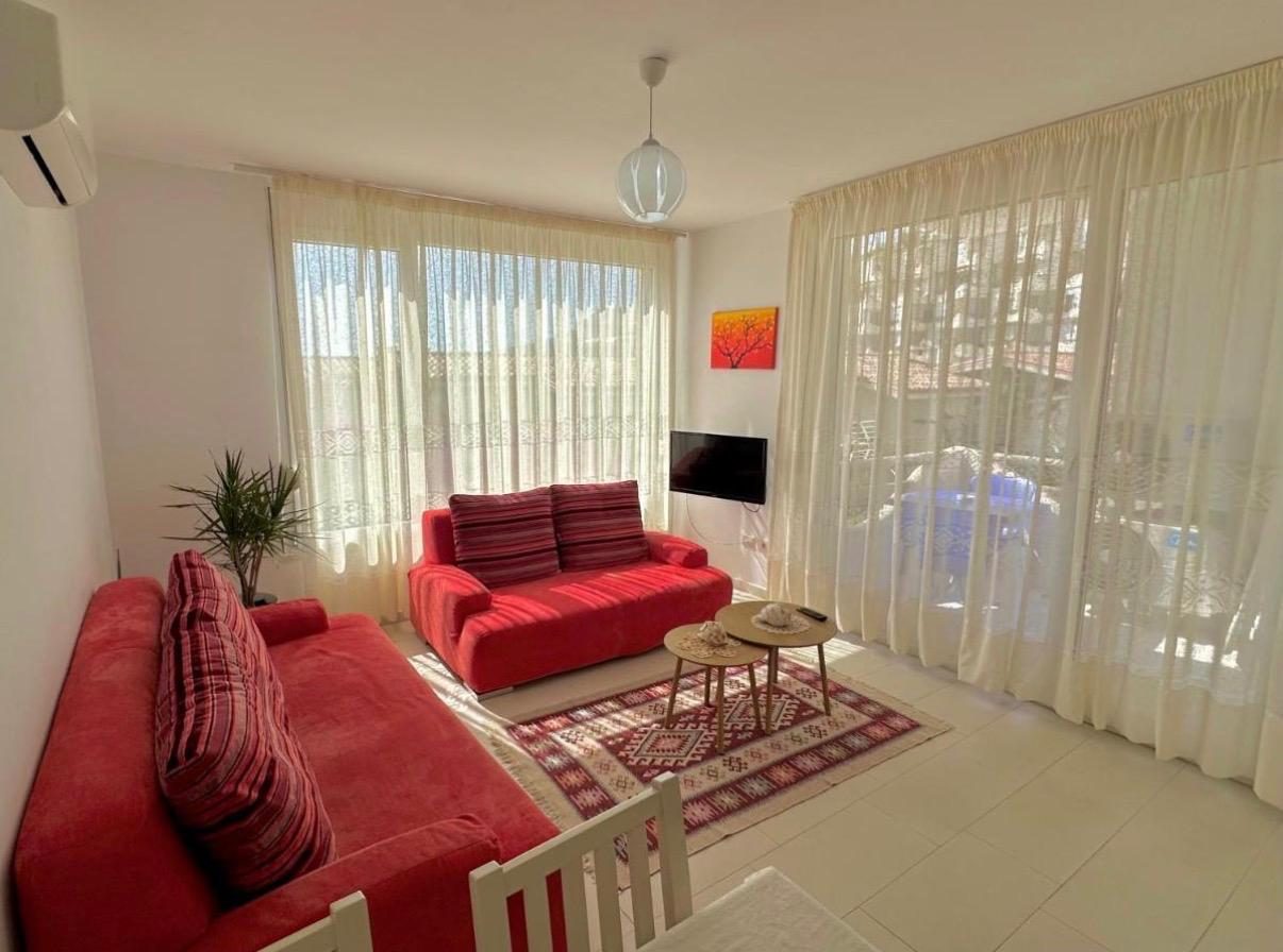 Living room with red sofas opening to a terrace