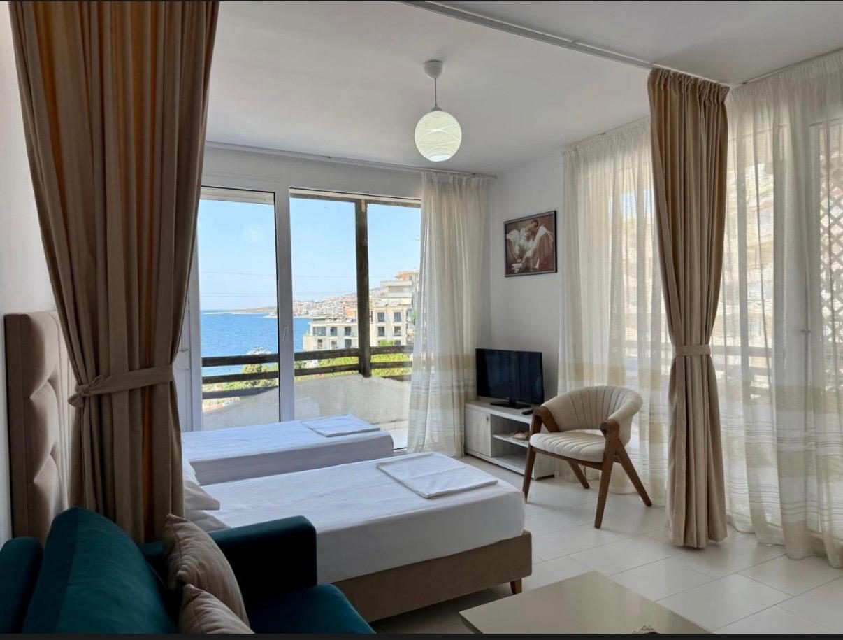 Studio with draped curtains, teal sofa and sea view